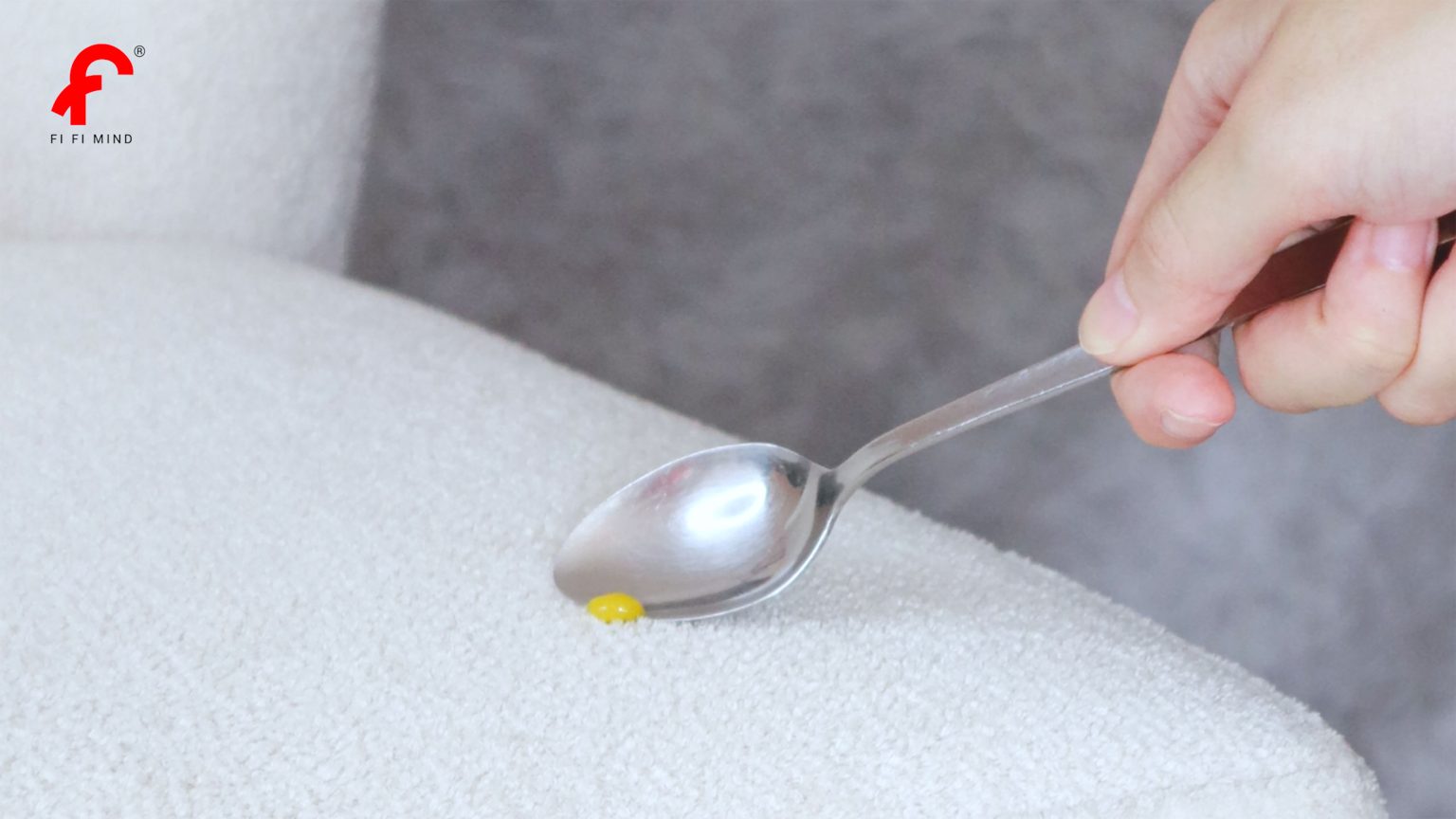 Using a spoon to remove excess residue of dhal curry from the white colour dining chair seat.